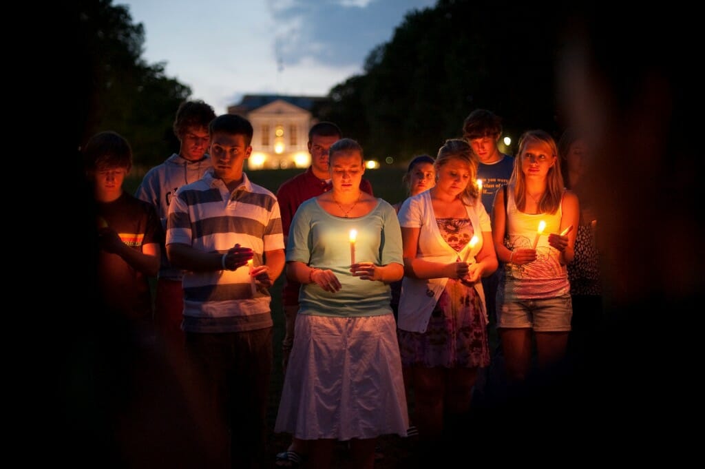 People holding lit candles in front of Bascom Hall