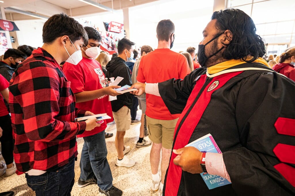 Person handing book to student