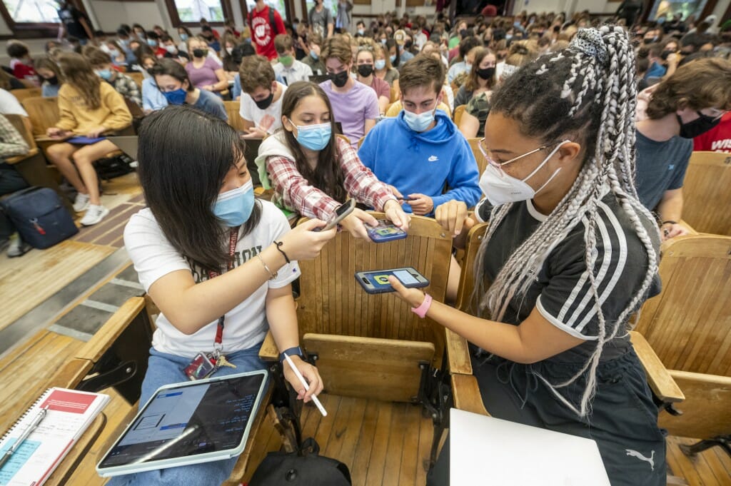 First-year students Joyce Ni, Sarah Rab, and Hannah Bertrand add each other as friends on Snapchat before the start of Chemistry 103 in Agricultural Hall.