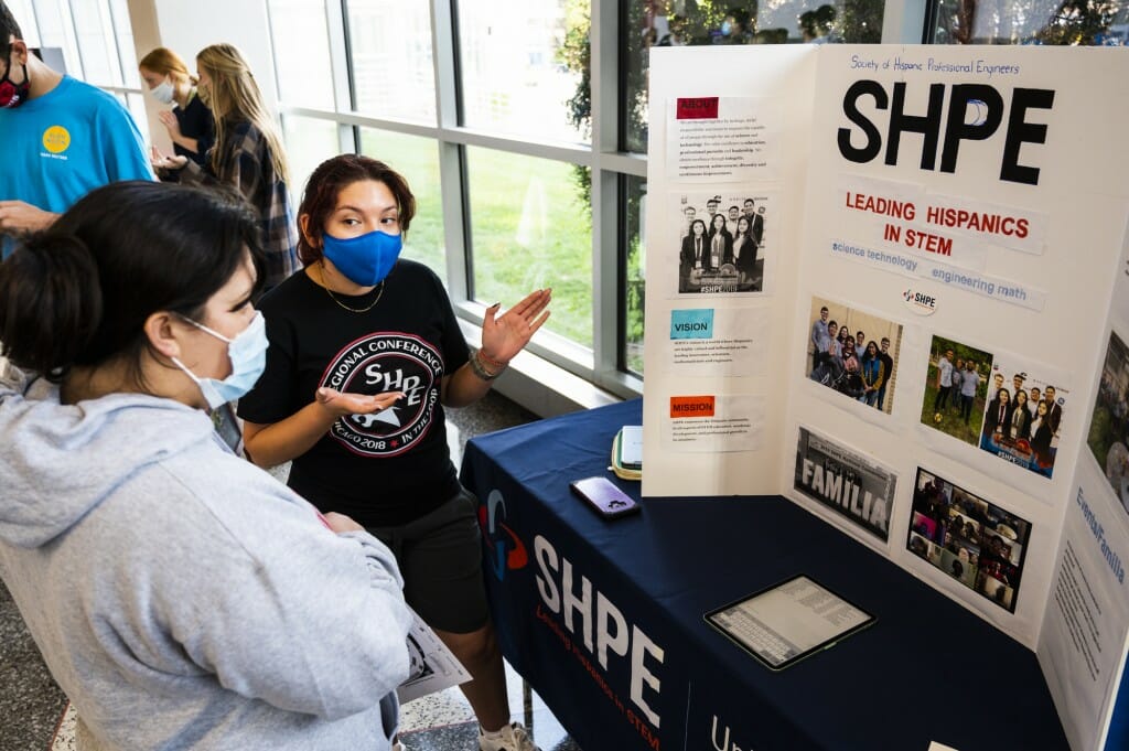 Christina Rivas, a senior, encourages a student to join the Society of Hispanic Professional Engineers.