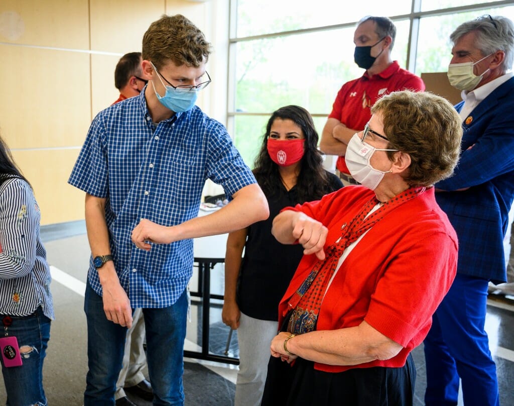 Microbiologist Jaret Schroeder uses an elbow bump to greet Chancellor Blank.