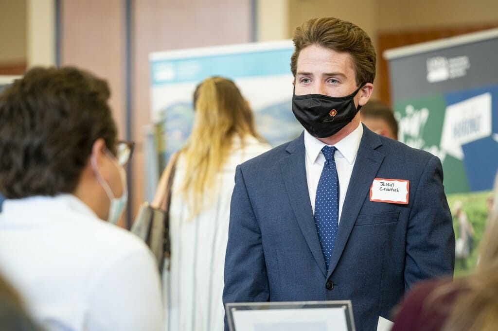 Student Justin Crawford (right) speaks with a recruiter.