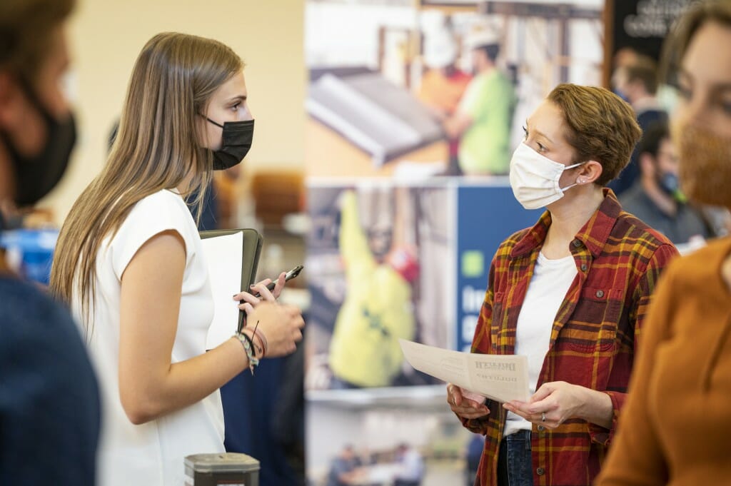 Student Camryn Ballweg (left) speaks with a recruiter from Duluth Trading Company.