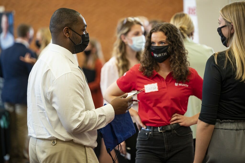 Student Thomas Collins (left) talks with recruiters from Wurth USA.