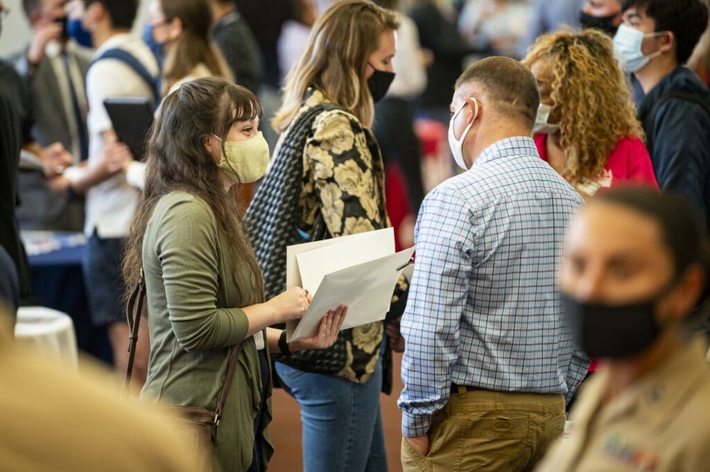 Student Bekka Ginzburg (left) talks with a recruiter.