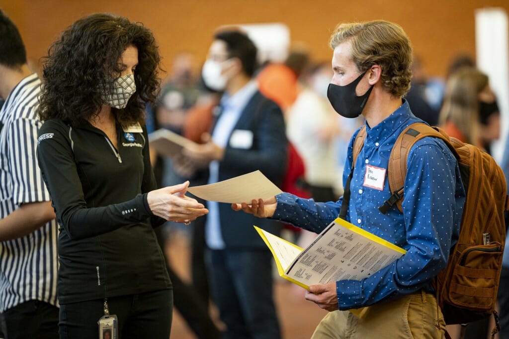 Student Ben Risseeuw (right) present a recruiter with his resume.