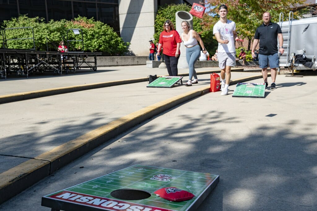 Ben Kemp and Michael Melendez play a game of UW-themed bag toss outside Union South.