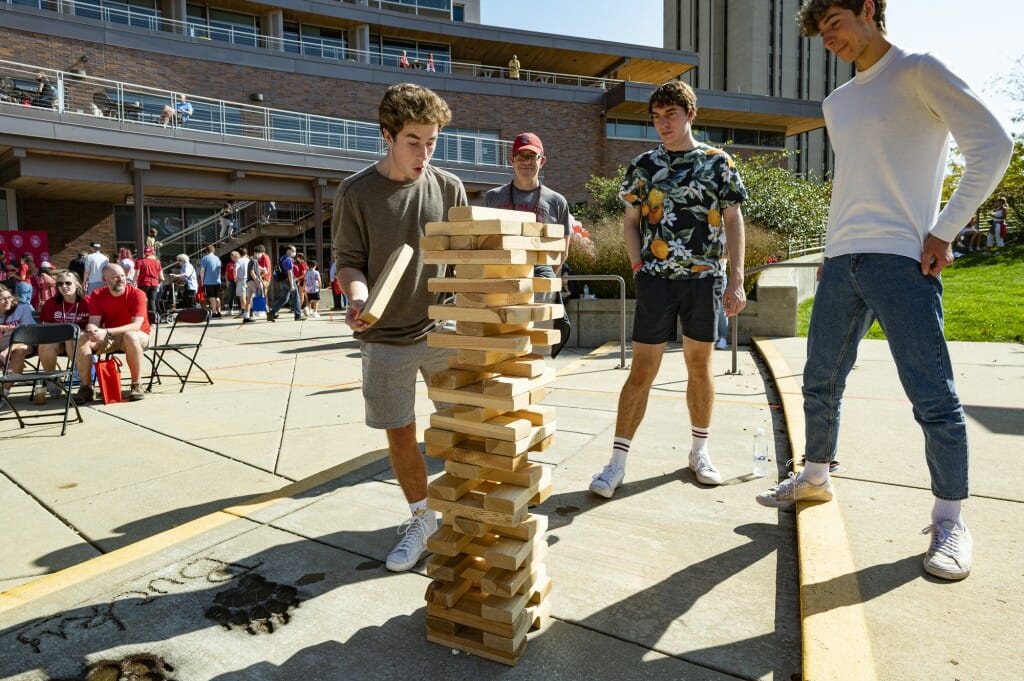 Eliiot Giffin, Sam Bradin and Sam Giffin play a game of oversized Jenga outside Union South.