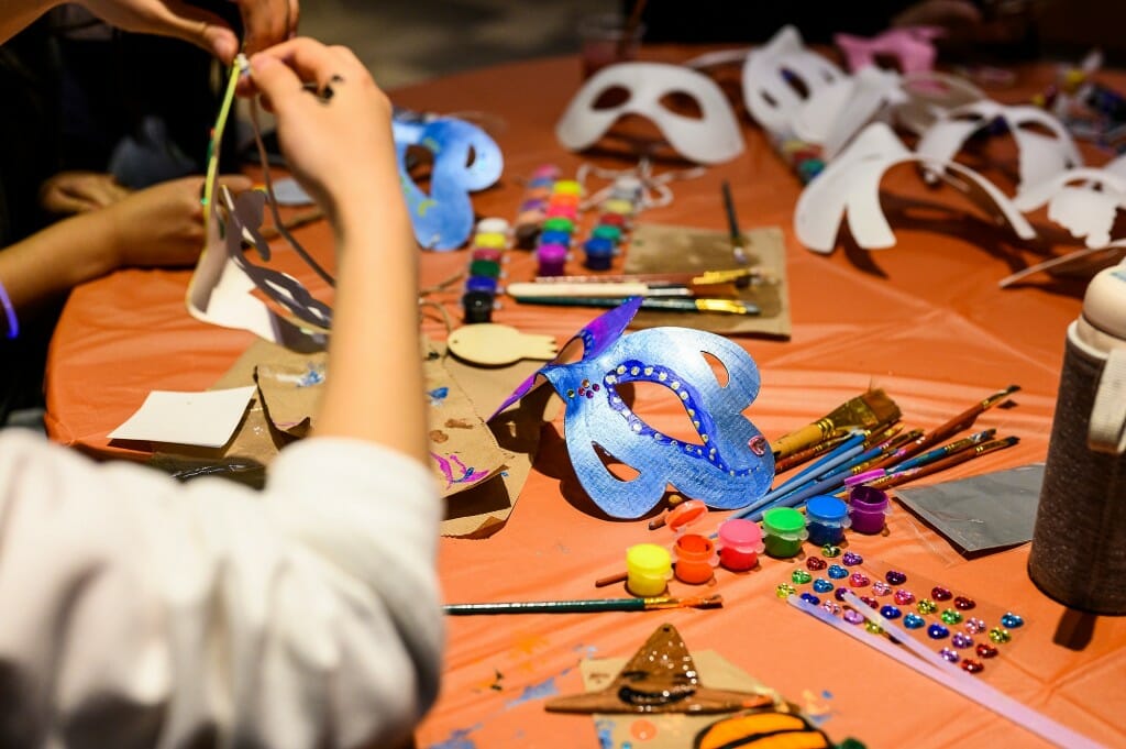 Students decorate masquerade masks.