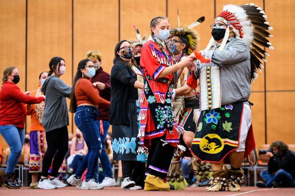 At right, UW-Madison alumni Grace Armstrong, head female dancer of Red Cliff Ojibwe, and David O'Connor, head male dancer of Bad River Ojibwe, lead a two-step community dance.