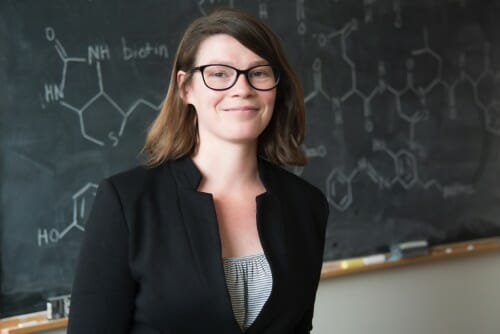 Portrait of Amy Weeks posing in front of a chalkboard