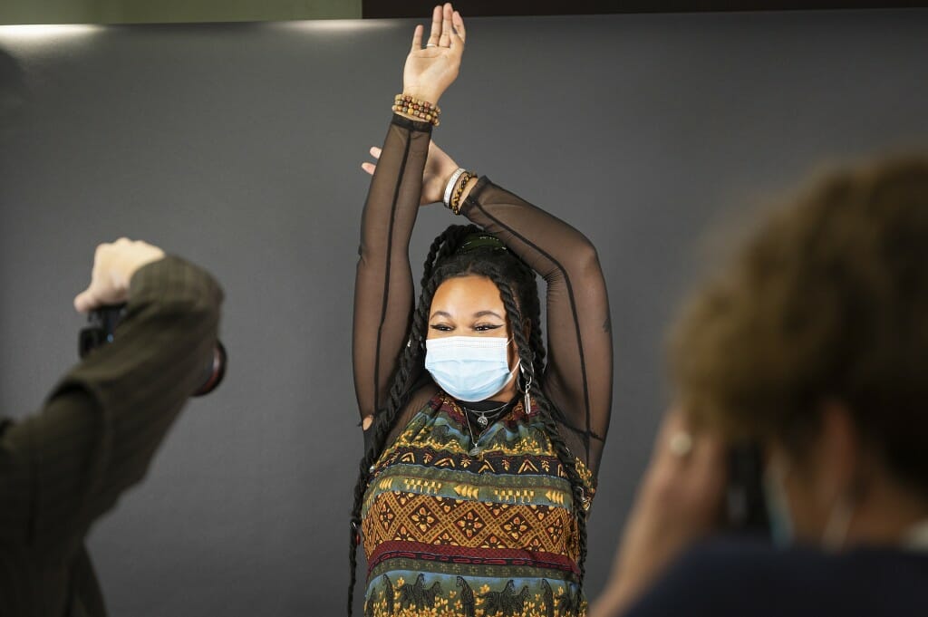 A woman stretches out as she poses for the camera.