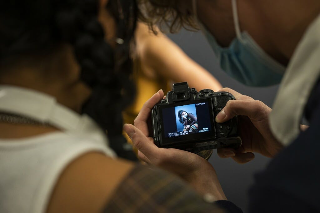 A woman looks at a photo in the window of a camera.