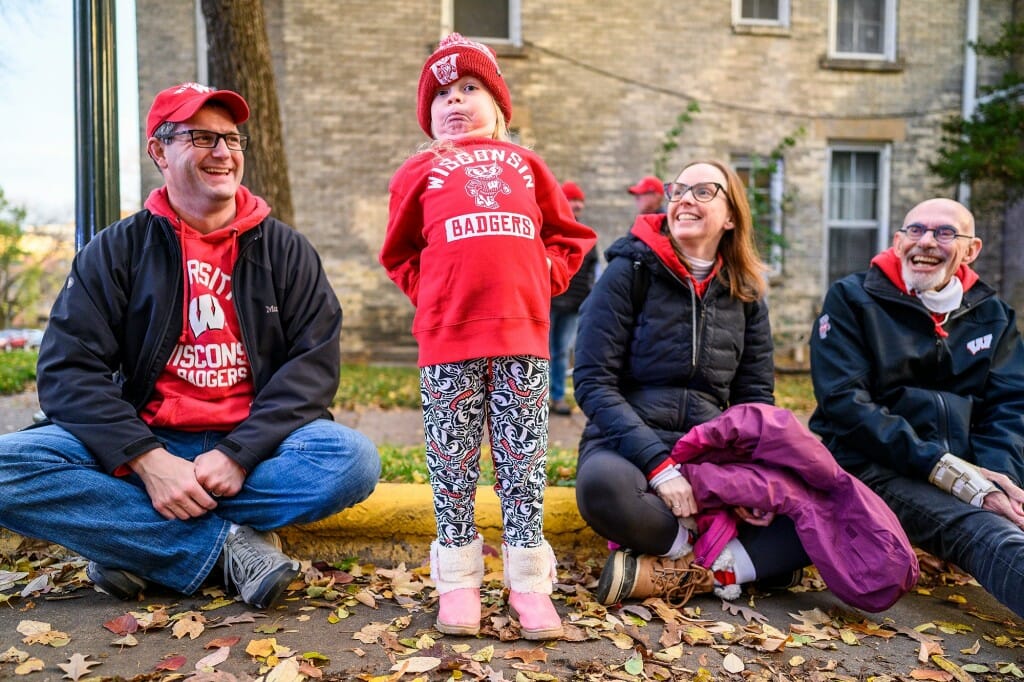 A child wearing Bucky Badger clothing strikes a pose of attention