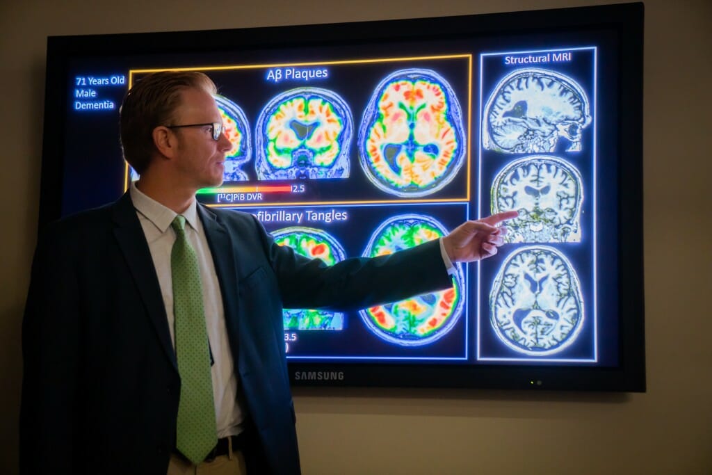 Sterling Johnson pointing to some brain scans projected on a screen