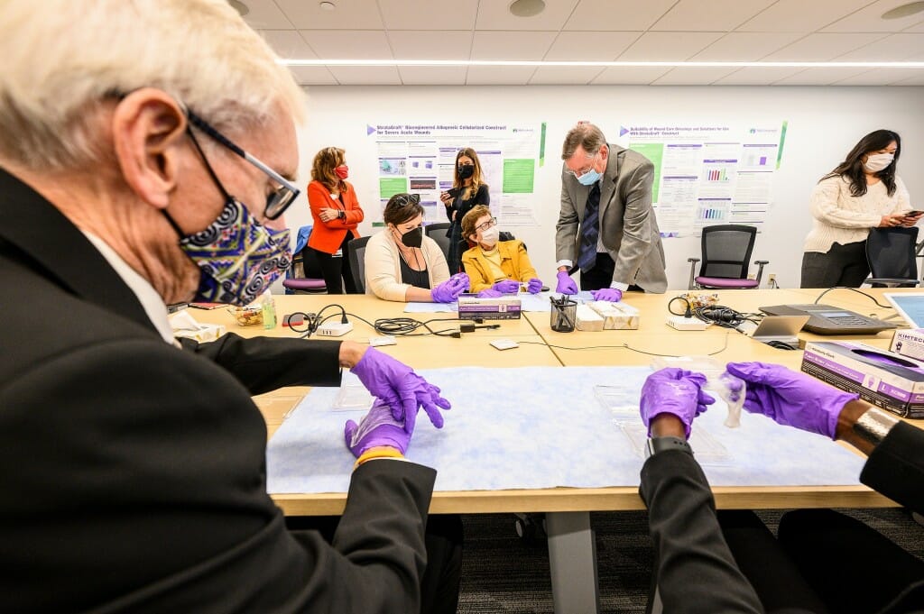 Several people sitting around a table and looking at samples