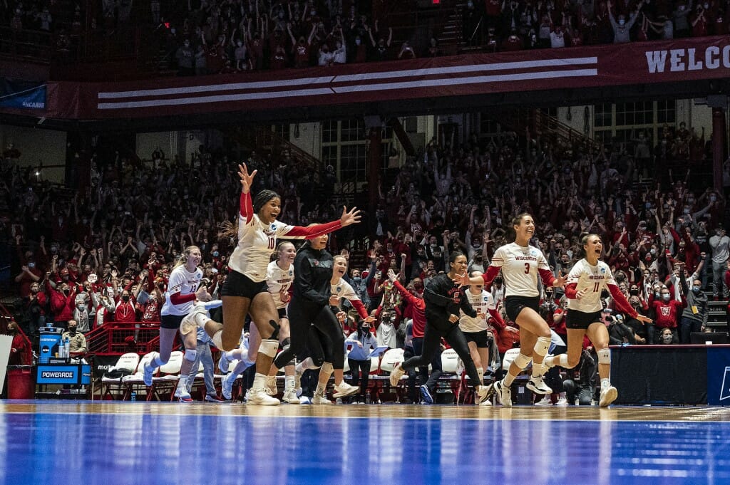 Team members come off the bench to celebrate the final set and match win.