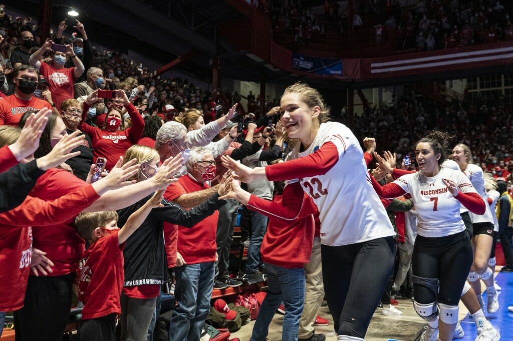 Julia Orzol and other members of the team run around the Field House giving hive fives after the big win.