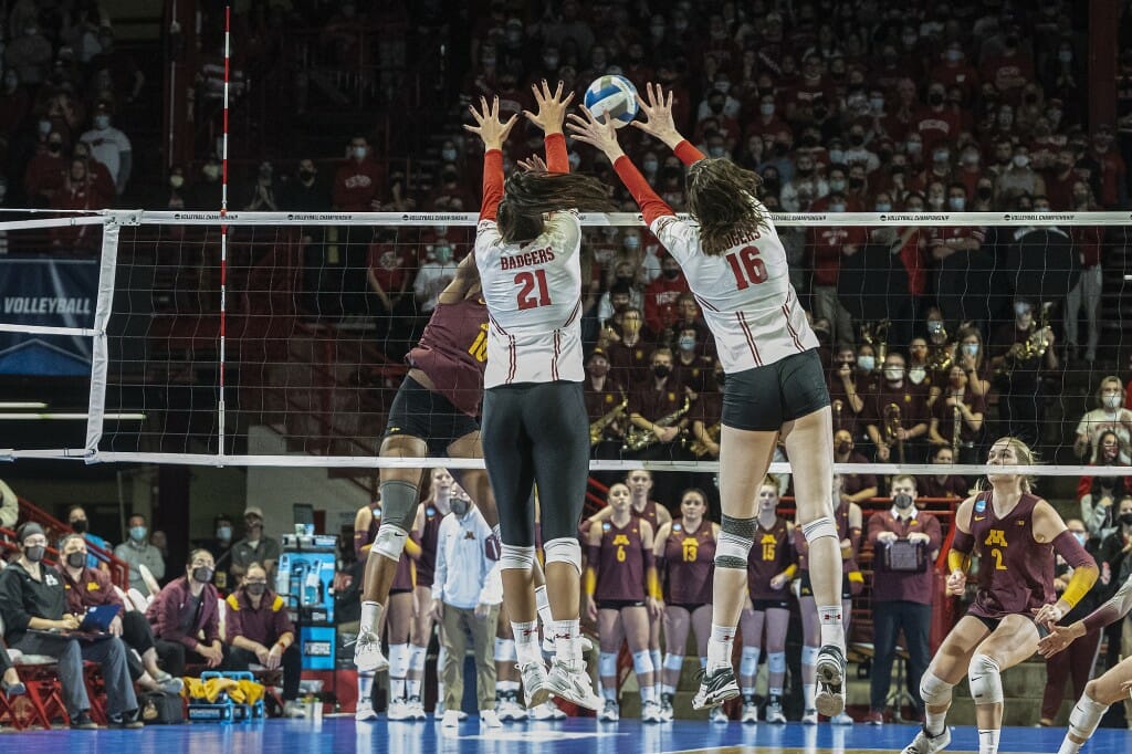 Grace Loberg (21) and Dana Rettke (16) finish a block.