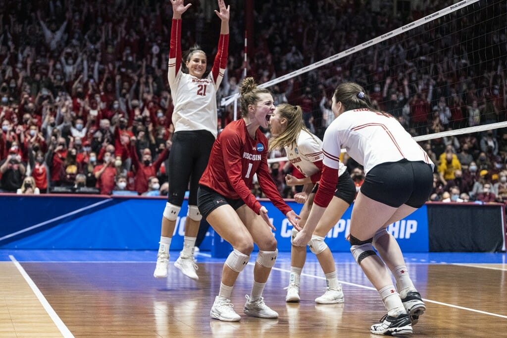 Lauren Barnes and Dana Rettke celebrate the match winning point while Grace Loberg raises her hands in victory.