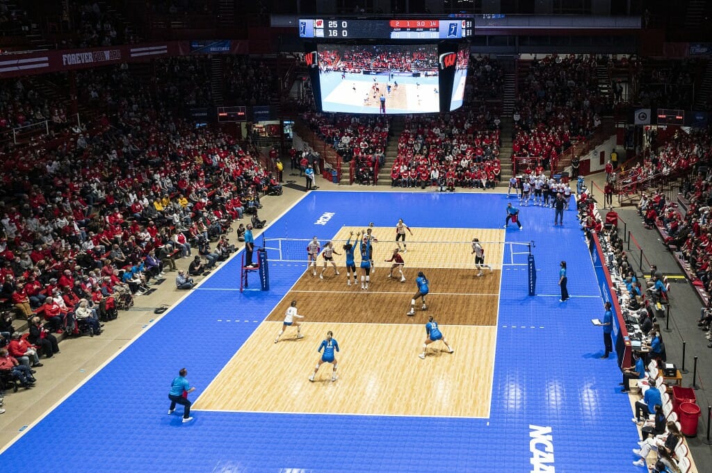 Wide shot of players on court with fans in bleachers