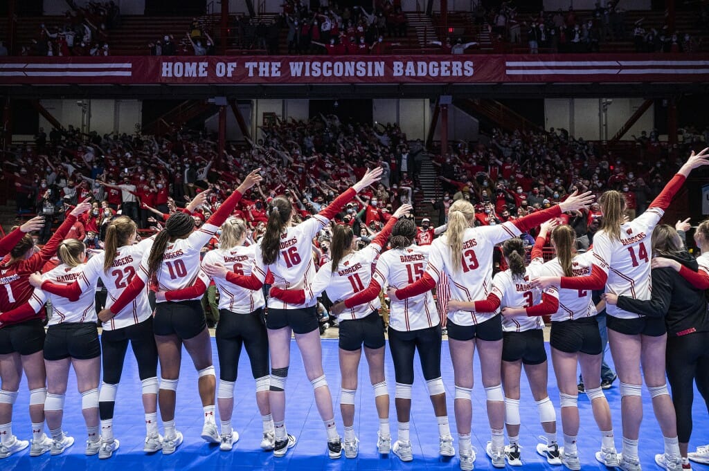 Team members lined up with their arms around each other, singing