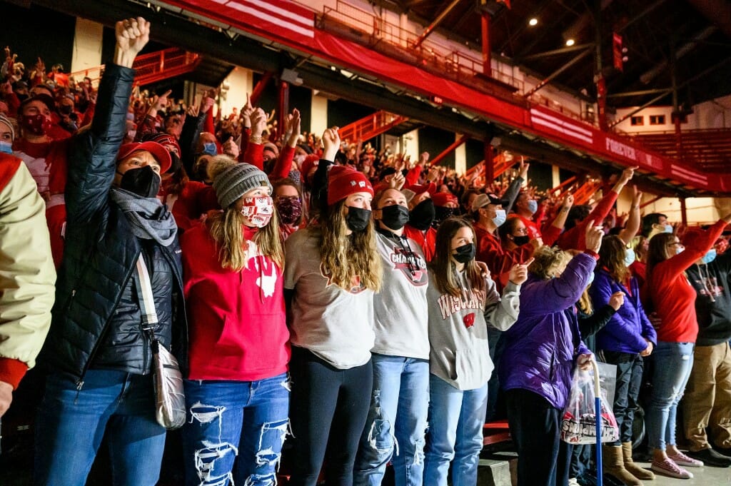 Members of crowd singing and waving arms