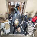 View from above looking down on students walking in and out of the front door.