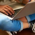 closeup of a young person holding a laptop computer