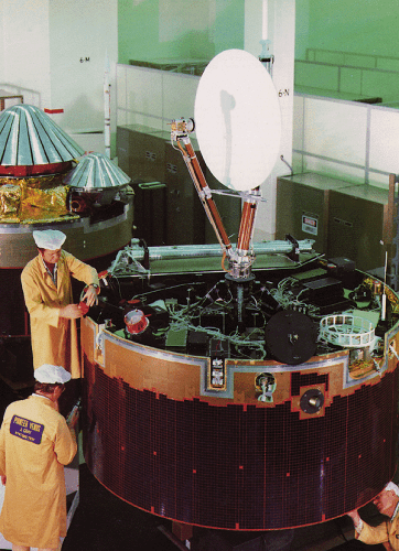 The Pioneer Venus Orbiter inside a building with two Pioneer Venus probes in the background.