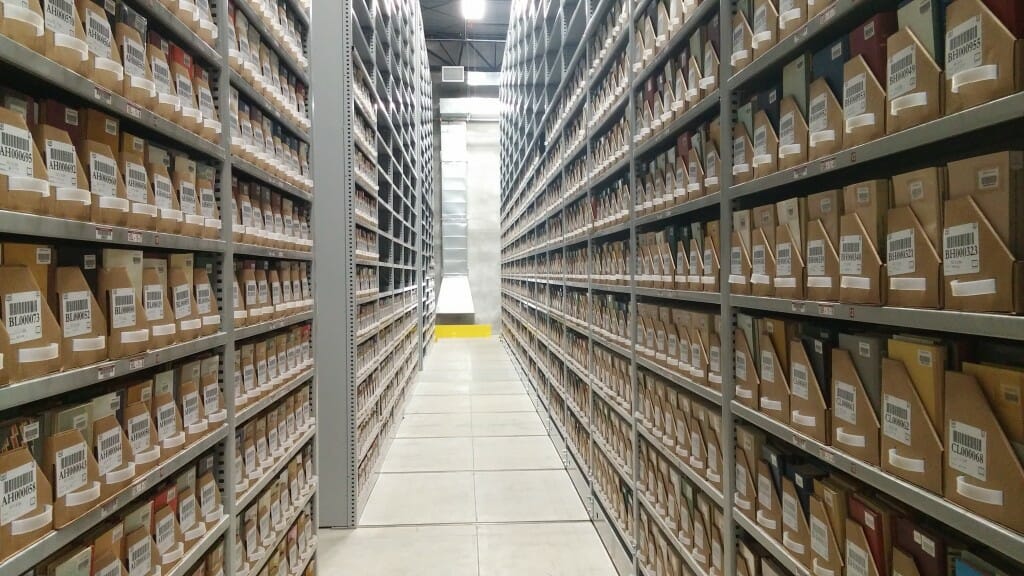 View looking down the aisle between 2 shelves containing document boxes