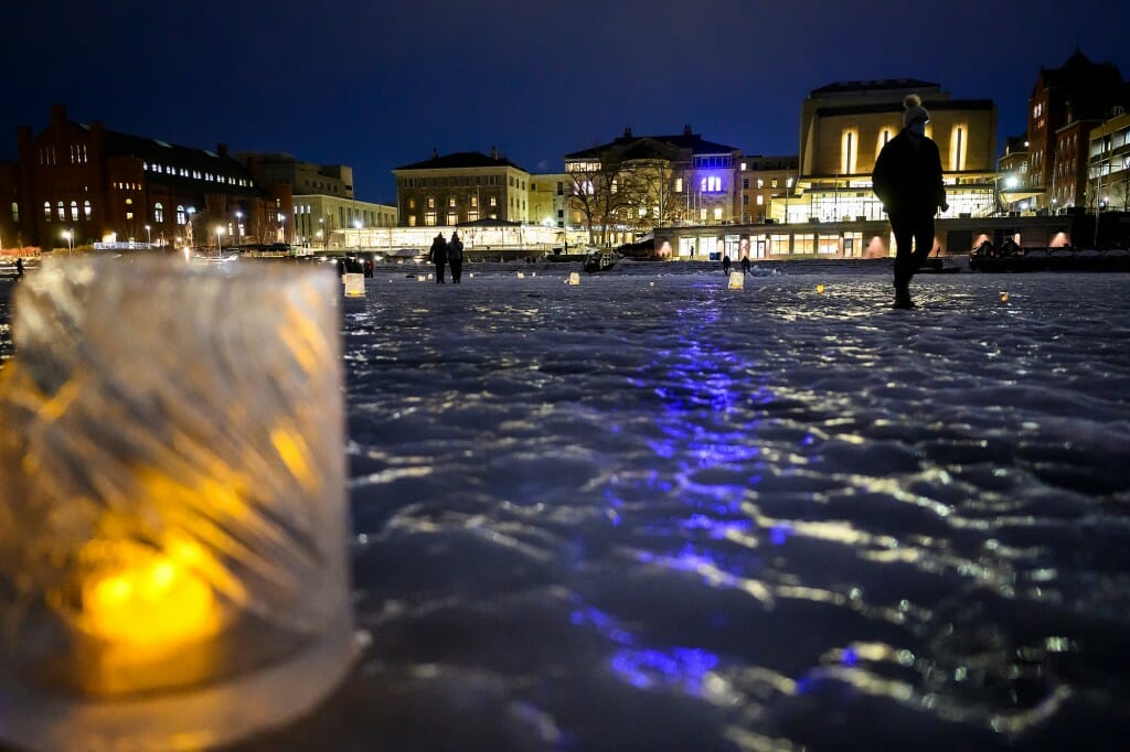 Participants walk a path lit by frozen luminaries on Lake Mendota near the Memorial Union Terrace.