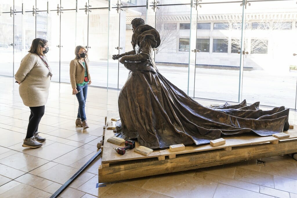 2 people looking at the statue in a glassy room at the Chazen