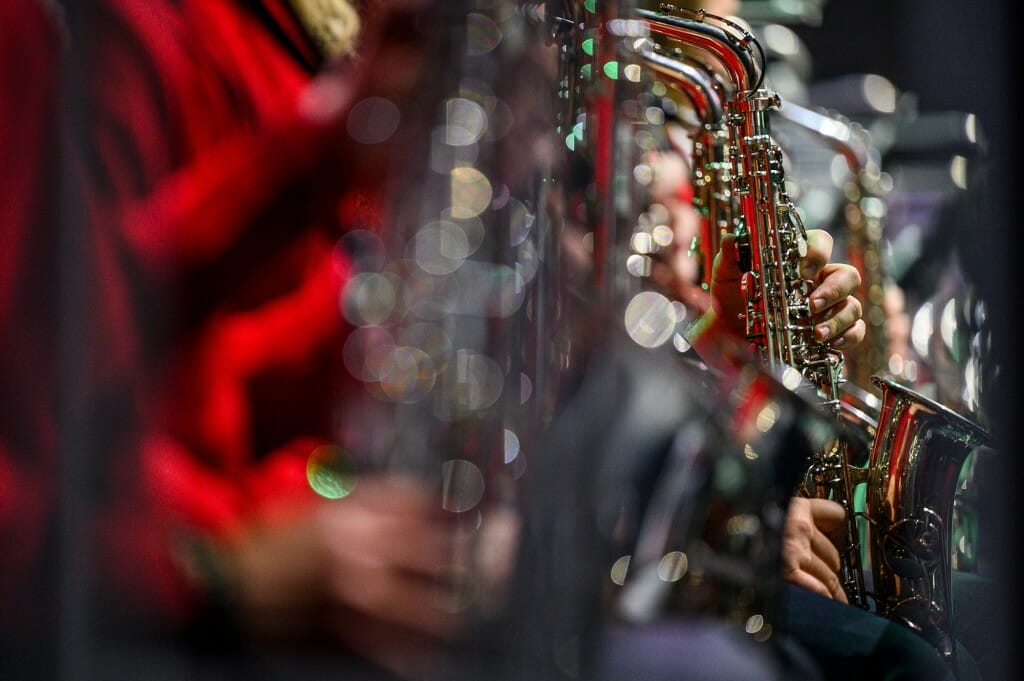 The saxophone section glimmers in the stage lights.