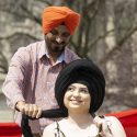 UW alum Gursharan Singh (left) ties a turban on a participant, who seems pleased with it.