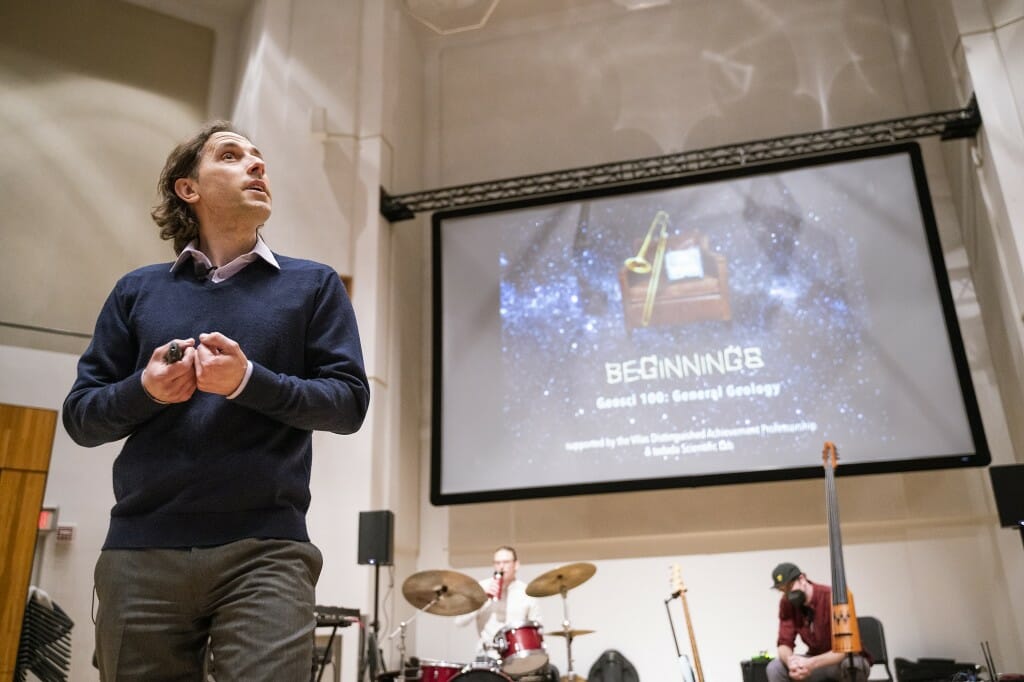 Stephen Meyers in a classroom standing in front of a large video projection screen