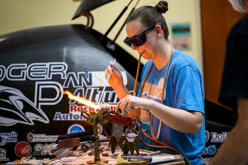 A bright flame heats glasswork as chemistry PhD student Meghan Campbell demonstrates scientific glass blowing while making a kaliapparat — a device for the analysis of carbon in organisms — in Chamberlain Hall.