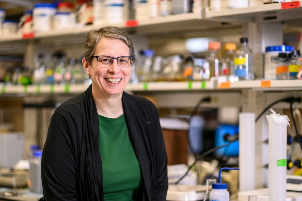 Portrait of Christine Sorenson posing in front of shelves with medical supplies