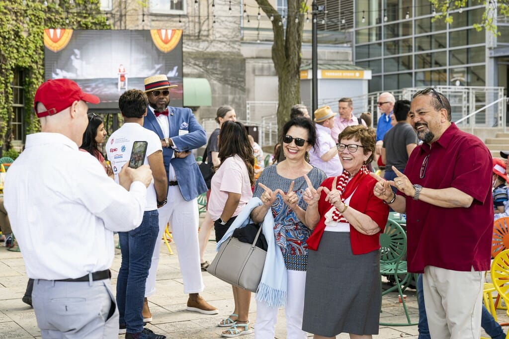 Several people posing for a photographer while holding their hands in 