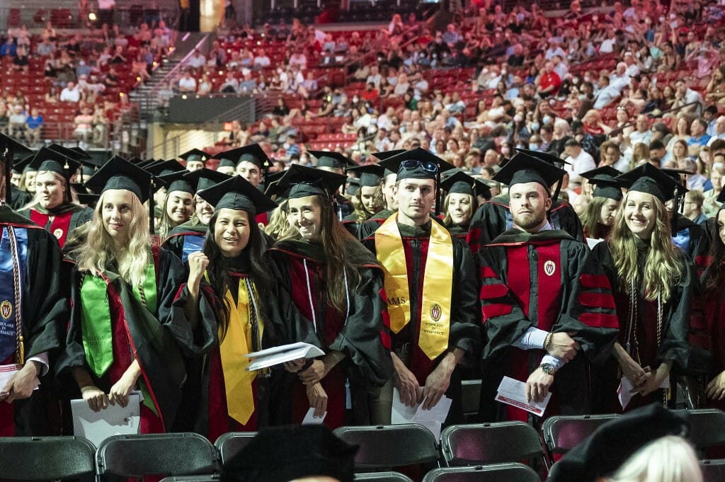 A row of seated graduates in caps and gowns