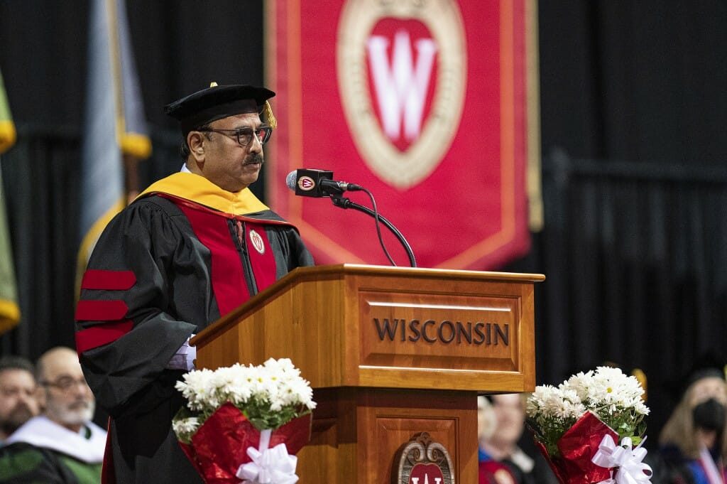 Ella, wearing academic cap, gown and stole, speaking at podium