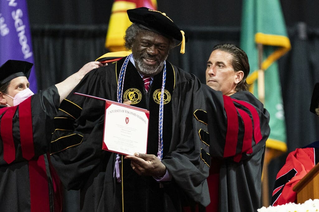 Grant, in academic cap and gown, holding a certificate