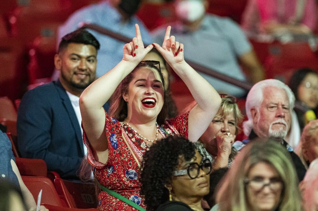 Person in crowd holding up fingers in 