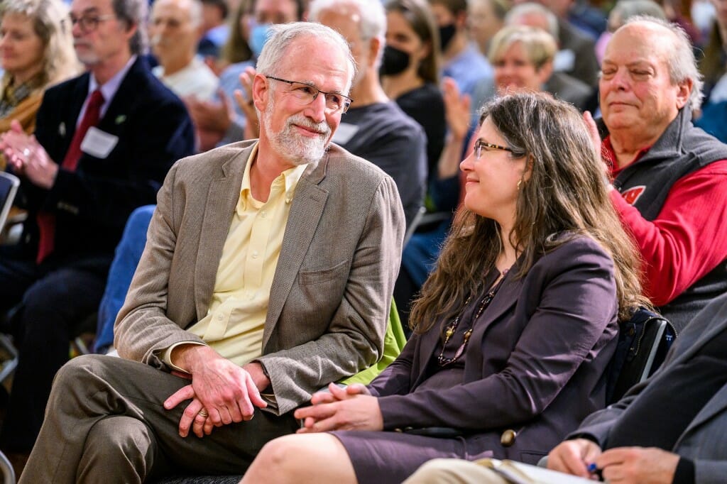 Bill and Jennifer glancing at each other in the front row