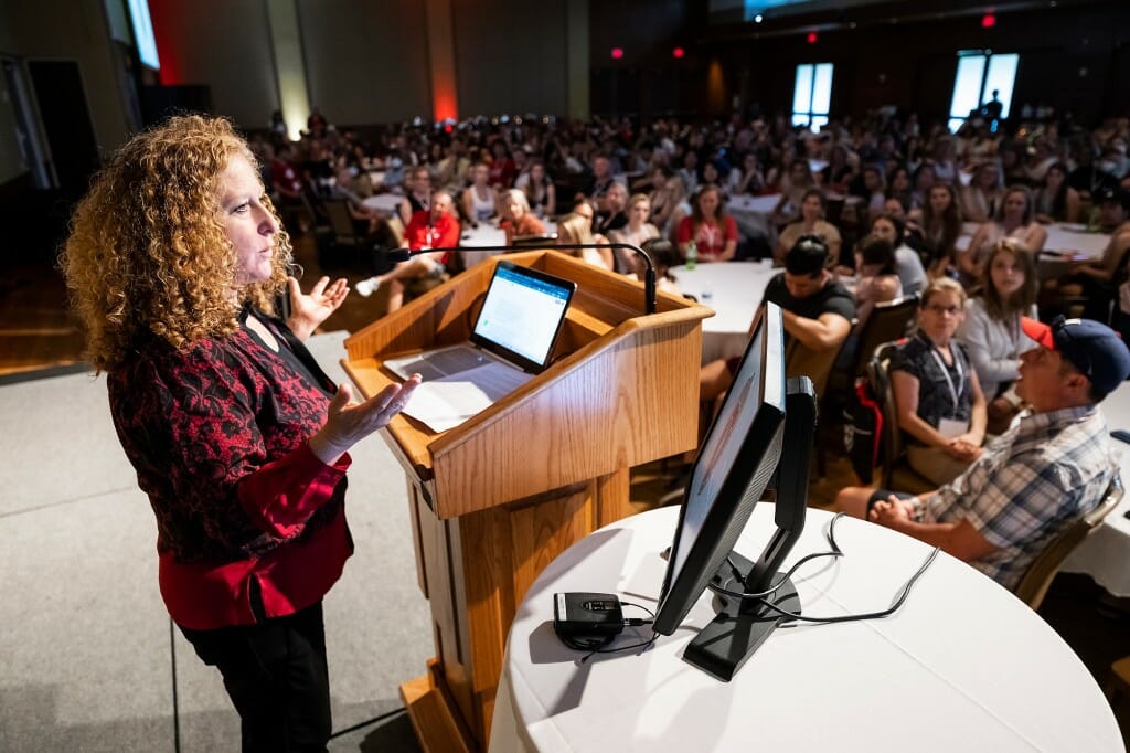 Mnookin speaking at a podium to a roomful of people