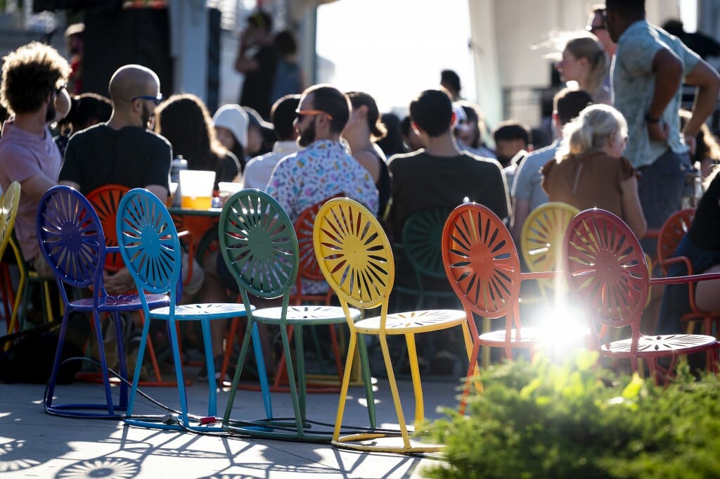 Terrace chairs arranged next to a group of people seated at outdoor tables