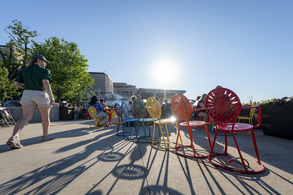 Terrace chairs cast shadows on the pavement in the sunlight