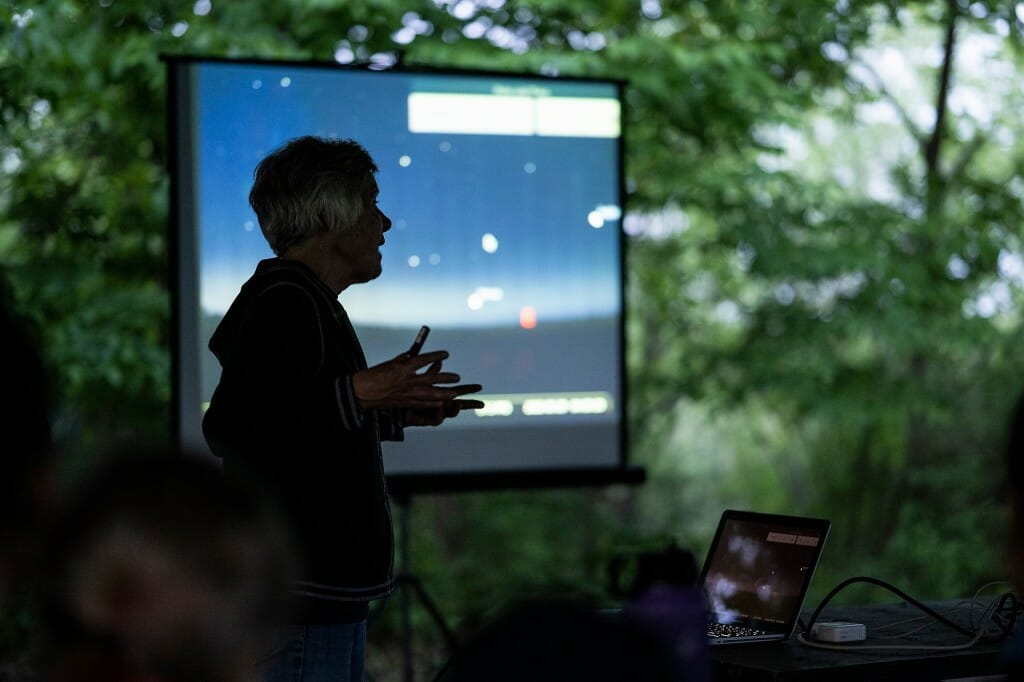 Silhouetted figure standing in front of a projection screen