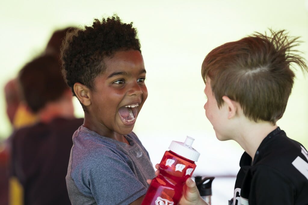 Children enjoy a fun lunchtime moment while participating in a UW boys' soccer day camp.