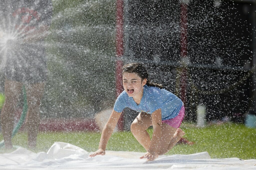 What better way to learn to slide at softball camp than to do it on a splash and slide?